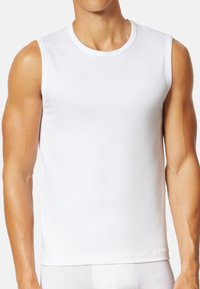 Weißes ärmelloses Tanktop aus Baumwolle, mit rundem Halsausschnitt und glatter Textur, entworfen für eine körperbetonte Passform. Keine Muster oder Verzierungen.