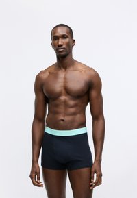 Black boxer shorts with a light blue Calvin Klein waistband, featuring a smooth texture and a fitted design.