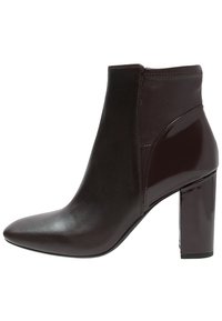 Ciemnobrązowy botek za kostkę wykonany z gładkiej skóry, z pointowanym nosem i błyszczącym obcasem w kształcie bloku. Posiada elegancki design i minimalne akcenty.