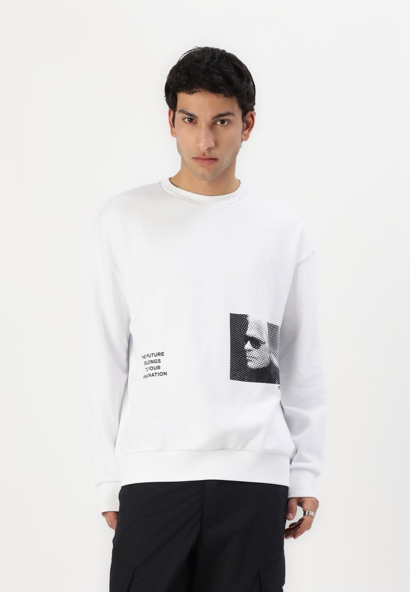 Hvit sweatshirt laget av bomullsblanding, med svart grafisk trykk og tekst på forsiden. Avslappet passform med ribbestrikkede mansjetter og hem.