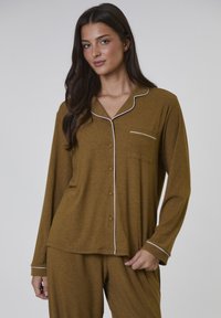 Brun långärmad pyjamas med en knäppbar topp, med en vit pipad krage och en bröstficka; mjuk, ribbad textur.
