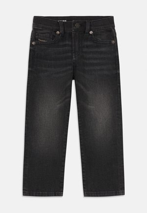 Jean en denim noir avec cinq poches, fermeture par bouton et fermeture éclair, et légère décoloration sur le devant des cuisses.