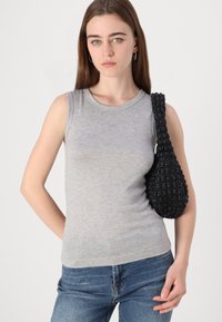 Hallituspetti hall pullover, mis on valmistatud puuvillast, omab ümarat kaelust ja diskreetset kolmnurga logo. Kaasas on tekstuuriga must kootud käekott.