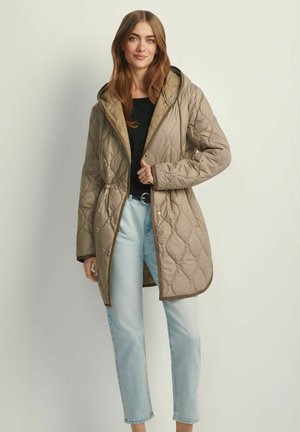 Beżowa pikowana kurtka z kapturem, zapinana z przodu na zatrzaski, z bocznymi kieszeniami. Tkanina ma gładką, błyszczącą fakturę.