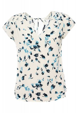Blouse crème à motif floral bleu et noir, manches courtes, col en V avec lien à nouer dans le dos.