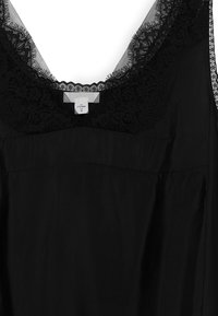 Black garment featuring a lace-trimmed neckline, lightweight fabric, and a smooth texture with a relaxed fit. Care label attached.