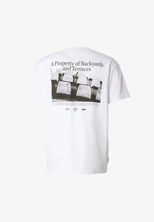 Bílé tričko s krátkým rukávem s černým grafickým motivem navršených kamenných bloků a textem "A Property of Backyards and Terraces" na zádech.