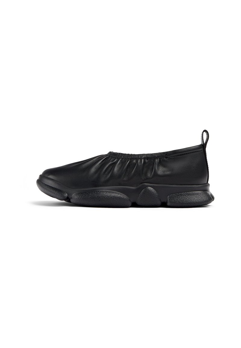 Svart slip-on sko laget av glatt skinn med rynket elastisk topp, rund tå og teksturert gummisåle. Minimalistisk design.