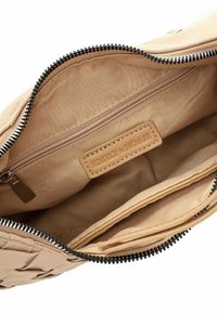 Beige woven handbag interior with a zip closure, featuring a fabric lining, an extra zipper pocket, and a brand label embossed on a leather patch.