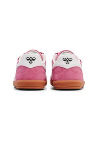Sneaker in suede rosa con accenti bianchi e suola in gomma, caratterizzate da un distintivo logo nero sul tallone e una superficie texturizzata.