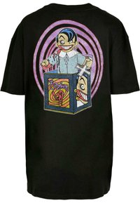 Camiseta de algodón negra con un gran gráfico colorido de un personaje espeluznante que emerge de una caja sorpresiva, con espirales en el fondo.