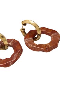 Złote kolczyki w formie kół z nieregularnie ukształtowanymi pomarańczowymi zawieszkami z żywicy, charakteryzujące się błyszczącą teksturą i różnorodnymi odcieniami kolorów.