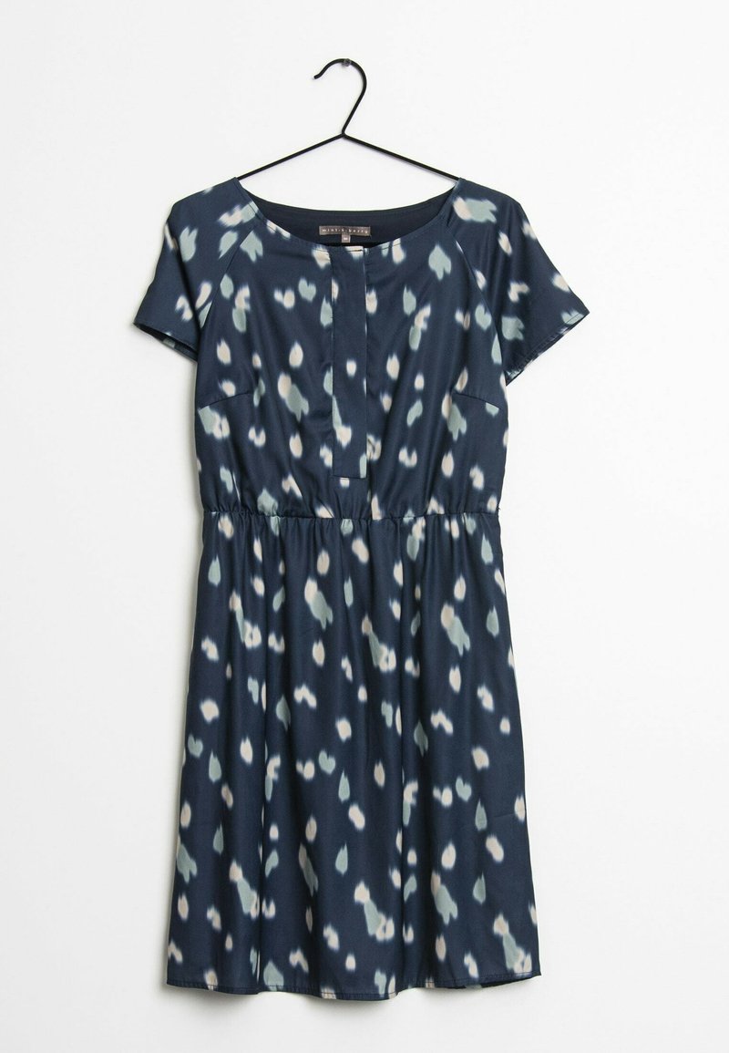 Robe bleu marine à manches courtes avec des taches irrégulières blanches et gris clair, taille cintrée, encolure ronde, suspendue sur un cintre noir sur fond blanc.