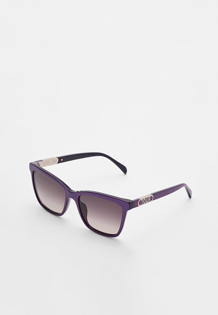 Fioletowe okulary przeciwsłoneczne o odważnym, kanciastym designie. Gradientowe soczewki przechodzą od ciemnych do jasnych. Posiadają srebrny akcent logo na zausznikach.