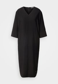 Robe noire longueur genou avec col en V, manches trois-quarts, et une fermeture éclair discrète au dos.