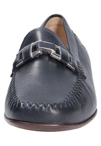Marine leren instapschoenen hebben een gestikt ontwerp, zilverkleurige hardware-accenten en een ronde neus met een gladde afwerking.