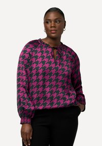 Langærmet bluse i pink og sort hundetand mønster, med en nøglehul-neck og elastiske manchetter. Glat stof med let glans.