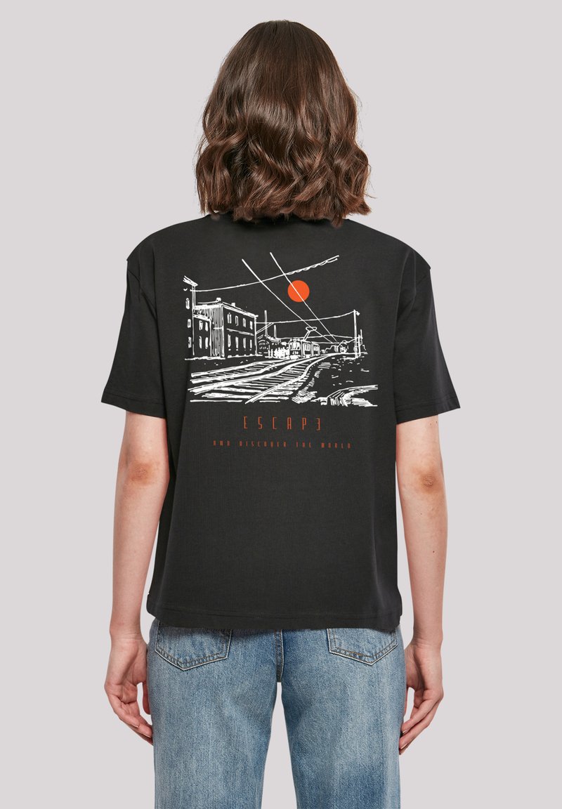 Schwarzes Baumwoll-T-Shirt mit einem Grafikdesign auf der Rückseite, das weiße Linienzeichnungen von Gebäuden und eine rote Sonne zeigt. Der Text lautet "ENTKOMMEN UND DIE WELT ENTDECKEN."