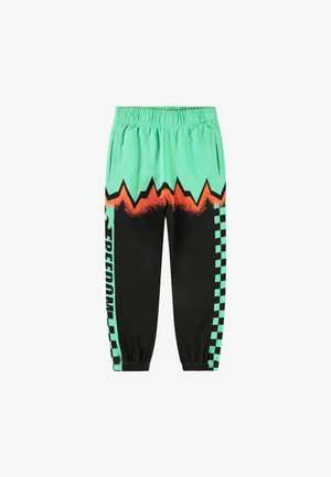 Zelené a černé tepláky s oranžovým zigzag vzorem, kostkovanými akcenty a elastickým pasem; zahrnují boční kapsy.