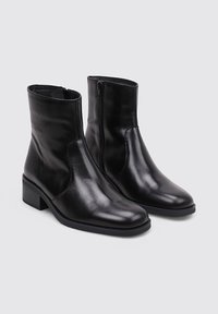 Black leather ankle boots with a smooth texture, rounded toe, low block heel, and a side zipper for closure.