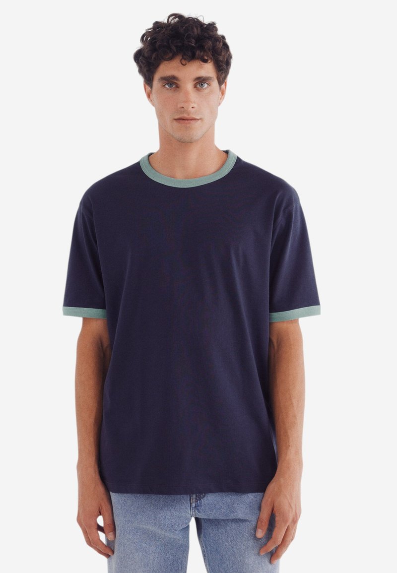 Mörkblå t-shirt med kort ärm och ljusgrön ribbad krage och ärmslut, tillverkad av mjukt tyg. Enkel, avslappnad passform.