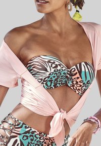 Strapless bikini top met dierenprint in bruin, teal en wit; lichtroze wikkelshirt geknoopt in de taille; kralenoorbellen en kleurrijke accessoires.