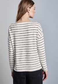 Gestreepte lange mouw top gemaakt van zacht materiaal, met zwart-witte horizontale strepen, een ruime halslijn en een relaxte pasvorm.