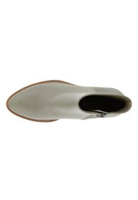 Bota de tobillo de cuero verde claro con punta afilada y cremallera lateral. Presenta un upper texturizado y una suela marrón contrastante.