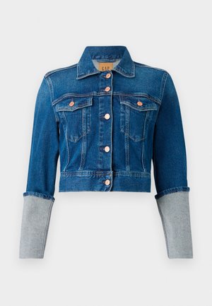 Korte donkerblauwe denimjas met koperen knopen, twee borstzakken, kraag en lichtgrijze omgeslagen mouwen.