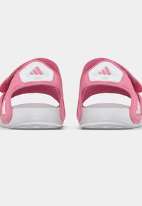 Roze sandalen met witte accenten, verstelbare banden en een gladde witte zool. Voorzien van het Adidas-logo op de band en de hiel.