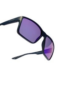 Occhiali da sole con montatura nera opaca e lenti specchiate viola. Presentano una forma geometrica e terminali delle tempie neri texturizzati.