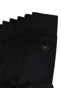 Calcetines negros fabricados con un material suave y elástico, con la parte superior acanalada y un pequeño logo impreso en gris en el lado.