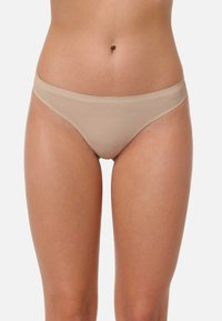 Sous-vêtements de style bikini nude avec une texture lisse et une couverture minimale; présente une taille basse et de fines bandes élastiques.