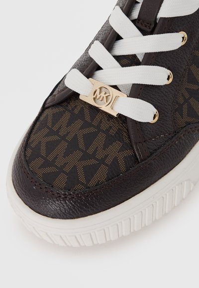 Baskets en cuir marron avec un motif monogramme. Dotées de lacets blancs et d'un accent logo doré. Surface texturée, semelle en caoutchouc.