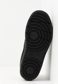 Svart gummisul med cirkulärt mönster, med en upphöjd Nike-logotyp och texten "ALL DAY PLAY" på undersidan.