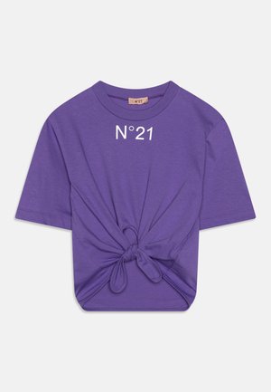 T-shirt en coton violet à manches courtes, avec un détail noué à l'avant et le texte "N°21" imprimé en blanc au niveau du col.