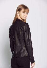 Schwarze Lederjacke mit taillierter Passform, ausgestattet mit einem Reverskragen, glatter Textur und Knopfdetails an den Ärmeln.