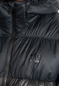 Black puffer jacket with a glossy finish, featuring a high collar, full zipper, and an embroidered adidas logo on the chest.