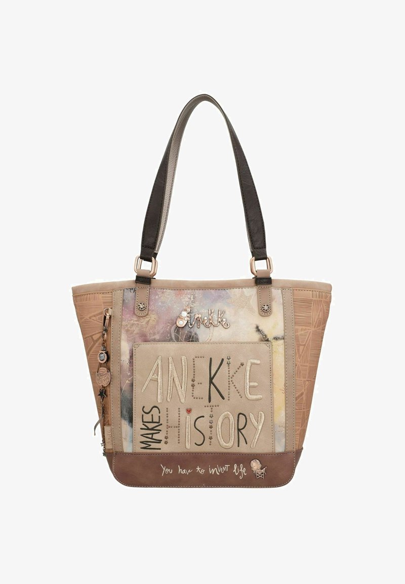 Beige-braune Tragetasche mit künstlerischer Schrift "Anekke macht Geschichte" und Anhängerdetails an einem Träger.