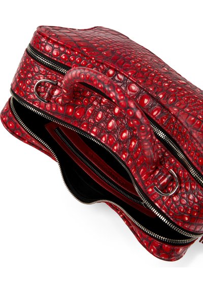 Sac en cuir rouge texturé avec motif crocodile, double fermeture éclair argentée partiellement ouverte, montrant un intérieur noir et une poche intérieure rouge.