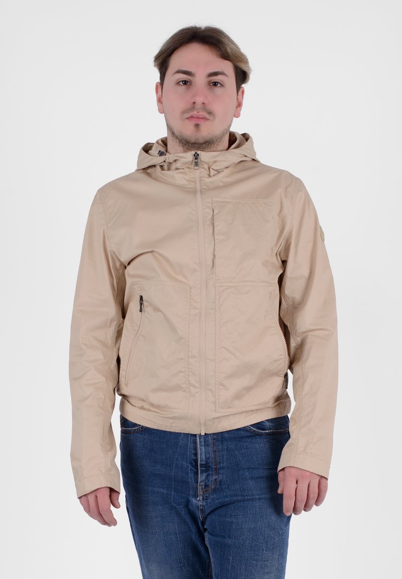 Giacca leggera beige con cappuccio, chiusura frontale a zip e due tasche laterali. Texture liscia e design semplice senza motivi visibili.