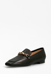 Zwarte leren loafer met een spitse neus, voorzien van een gouden kettingaccent over de bovenkant en een lage blokhak. Glad van textuur.