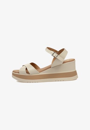 Sandalias de cuña beige con tiras entrecruzadas, correa de tobillo ajustable, plantilla acolchada y una plataforma texturizada con una banda de acento marrón.