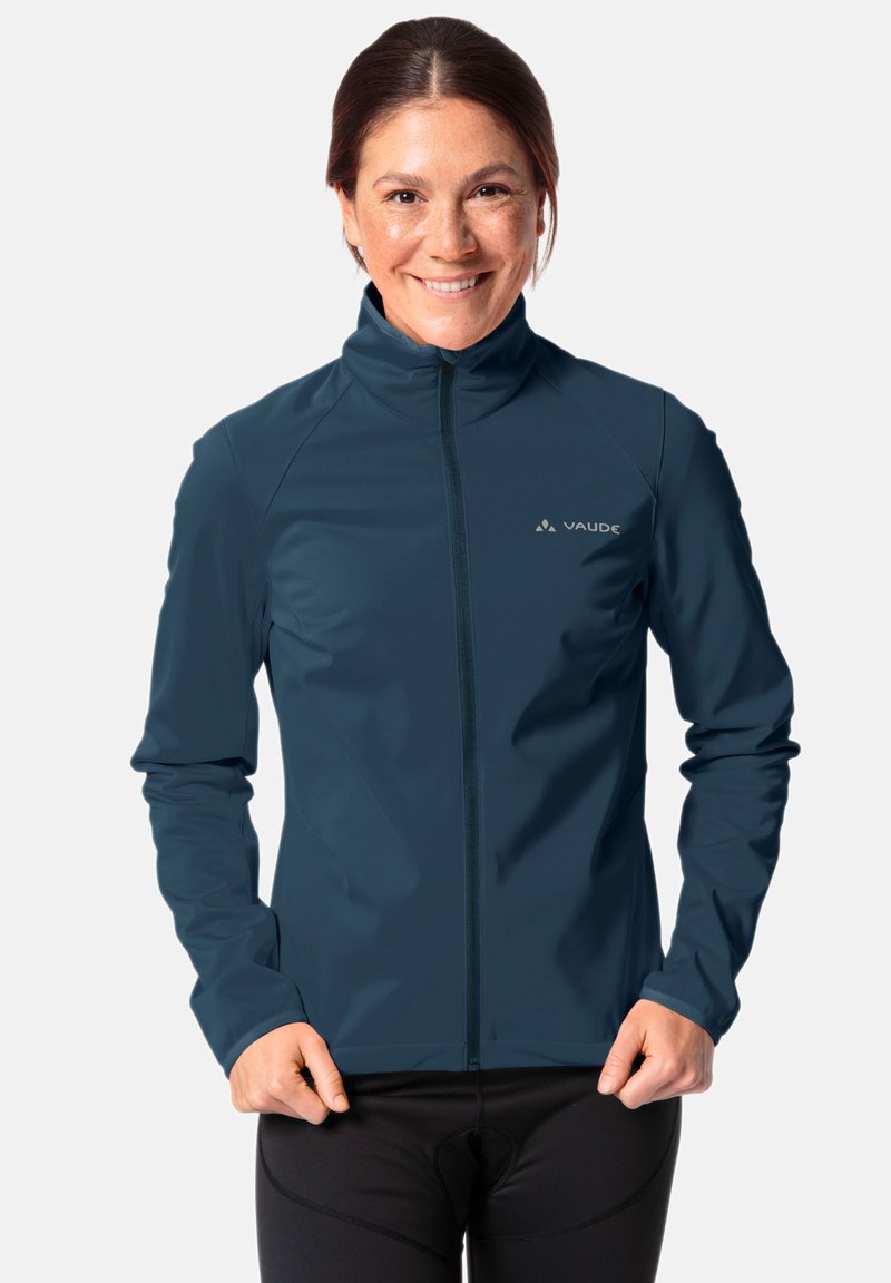 Giacca blu con zip realizzata in un tessuto liscio e elastico, con colletto alto. Presenta un logo sul lato sinistro del petto e maniche aderenti.