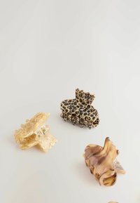 Štyri sponky do vlasov: jedna krémovo mramorovaná, jedna s leopardím vzorom a dve hnedé so swirl vzorom, všetky vyrobené z lesklého plastu s dizajnom drápu.