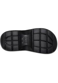 Suela de zapato de goma negra con patrones de agarre texturizados, que presenta grandes rectángulos y círculos elevados para tracción y durabilidad.