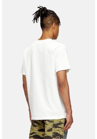 Hvid bomulds t-shirt med korte ærmer, rund hals og lige kant. Stoffet fremstår glat med en let stræk.