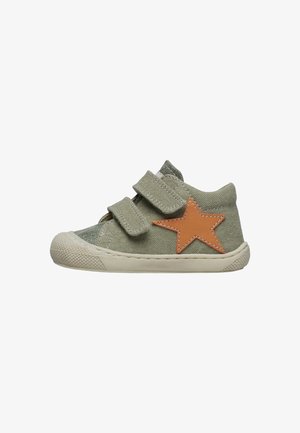 Sneaker verde in tela con due fascette in velcro, un'applicazione a forma di stella marrone e suola in gomma bianca, caratterizzata da un tessuto testurizzato e puntale rinforzato.