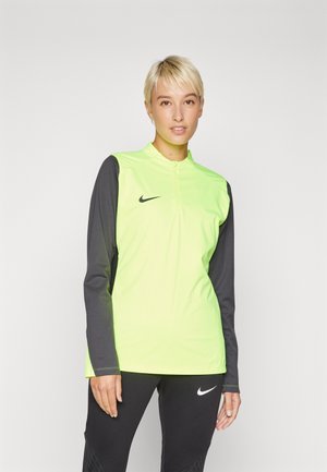 T-shirt à manches longues Nike avec un devant jaune-vert vif et des manches gris foncé, doté d'un col zippé quart et d'un accent logo noir.