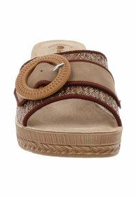 Sandale en daim tan avec un design tressé, des sangles d'accent marron, une grande boucle circulaire et une semelle en caoutchouc texturé.